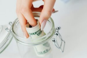 Glass jar filled with cash representing an emergency fund for financial security