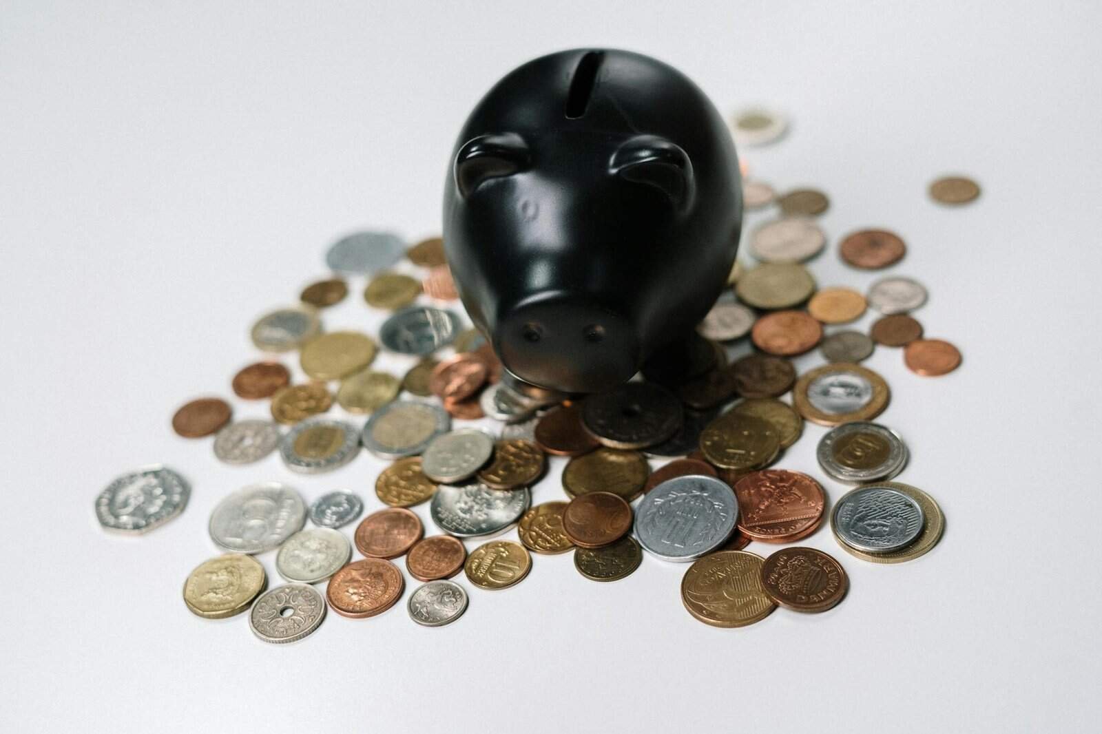 person saving coins in piggy bank showing how to save money fast on a low income